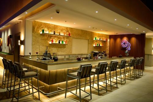 a bar in a restaurant with a bunch of stools at Clarion Hotel Jeddah Airport in Jeddah