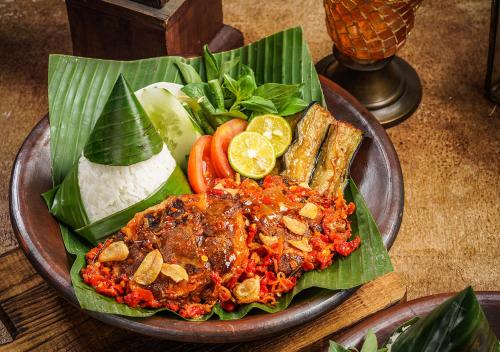 a plate of food with meat and vegetables on a table at AYANA Midplaza JAKARTA in Jakarta