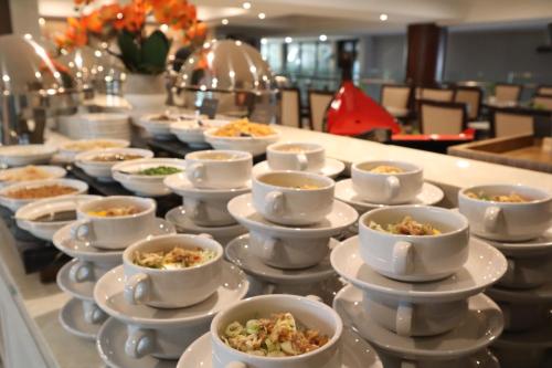 a buffet line with bowls and plates of food at Dream of Aventus Hotel Kuta in Kuta