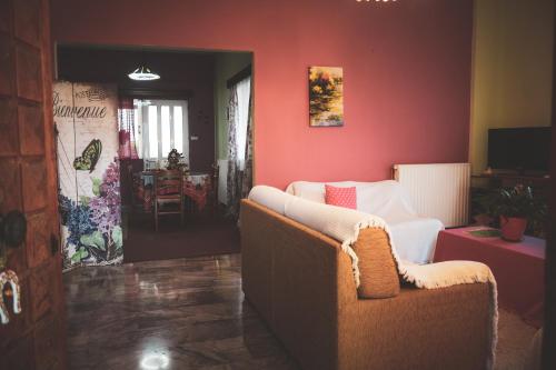 a living room with red walls and a couch and a table at Georgia's Village House in Kondóstavlos