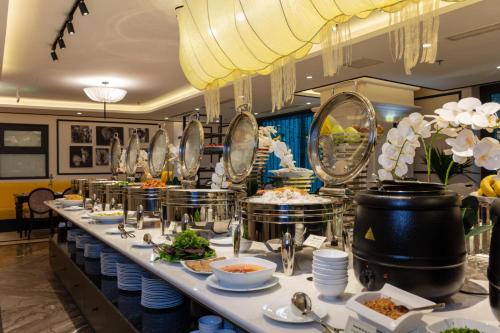 a buffet line with dishes and food in a restaurant at FTE Ba Dinh Hotel in Hanoi