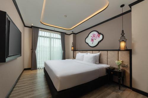 a bedroom with a large bed and a television at FTE Ba Dinh Hotel in Hanoi