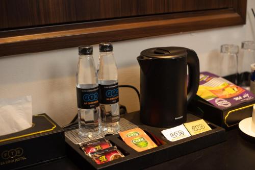 two bottles of coke and a coffee maker on a table at FTE Ba Dinh Hotel in Hanoi