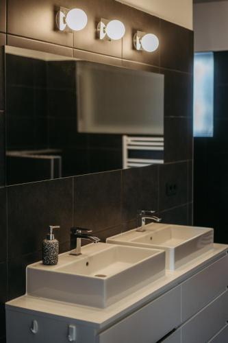 a bathroom with two sinks and a large mirror at Mareli Neusiedler Stadthaus in Neusiedl am See