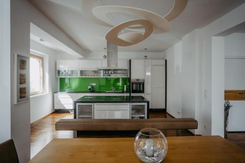 uma cozinha com uma mesa de madeira e uma cozinha verde em Mareli Neusiedler Stadthaus em Neusiedl am See