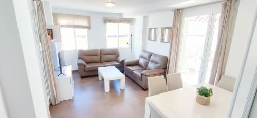 Apartamento Los Mares by DENIA COSTA في دينيا: غرفة معيشة مع أريكة وطاولة