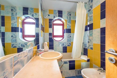 アルブフェイラにあるVilla Marinaの青と黄色のタイル張りの壁のバスルーム(シンク付)