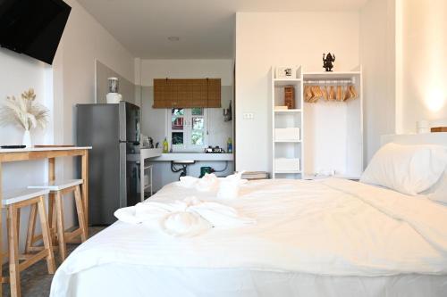a large white bed in a room with a kitchen at Bao Village in Haad Yao