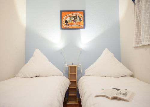 2 Betten in einem Zimmer mit einem Buch auf dem Bett in der Unterkunft Lindenhof am See in Winterberg