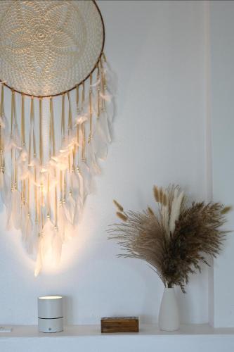 a chandelier hanging from a white wall with a plant at Bao Village in Haad Yao