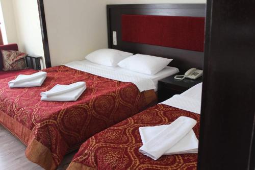 a hotel room with two beds with white towels on them at Adrasan Klados Hotel in Adrasan