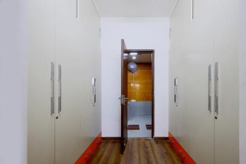 a hallway with white doors and a wooden floor at InnBox Farmstay - Rajpura Punjab in Banūr