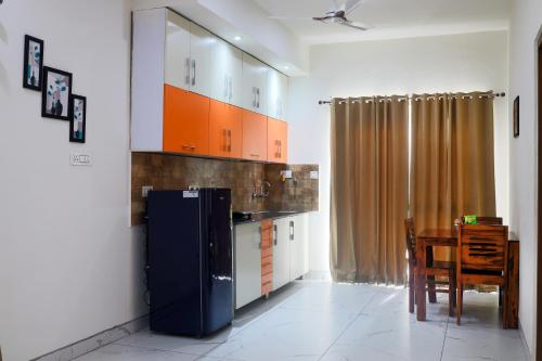a kitchen with a blue refrigerator and a table at InnBox Farmstay - Rajpura Punjab in Banūr