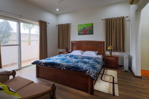 a bedroom with a bed and a large window at InnBox Farmstay - Rajpura Punjab in Banūr