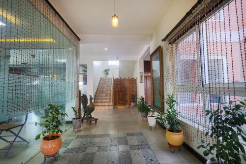 a hallway with potted plants and stairs in a building at InnBox Farmstay - Rajpura Punjab in Banūr