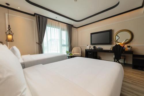 a hotel room with two beds and a television at FTE Ba Dinh Hotel in Hanoi