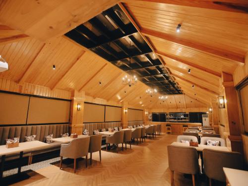 a dining room with tables and chairs and wooden ceilings at Clarks Inn Express, Dehradun in Dehradun