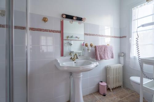 a white bathroom with a sink and a shower at Maison Art Deco-5 suites, piscine, clim, parking in Labouheyre