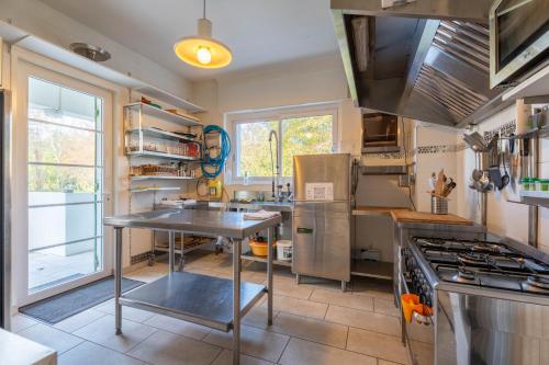 a kitchen with a table and a stove at Maison Art Deco-5 suites, piscine, clim, parking in Labouheyre