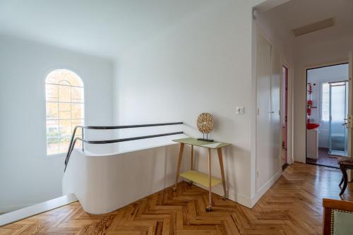 a white room with a staircase and a table at Maison Art Deco-5 suites, piscine, clim, parking in Labouheyre