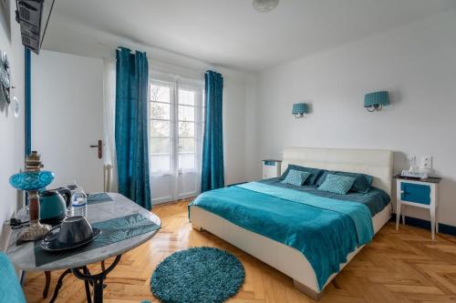 a bedroom with a bed and a table at Maison Art Deco-5 suites, piscine, clim, parking in Labouheyre