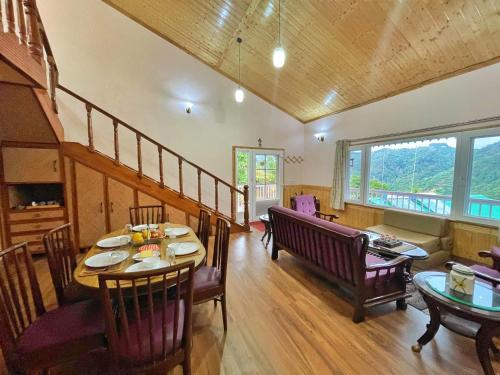 a dining room with a table and chairs and a window at ROSASTAYS Mukteshwar Rosa Parvada in Mukteswar