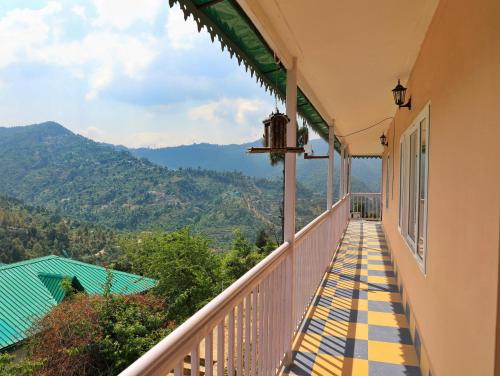 a balcony with a view of the mountains at ROSASTAYS Mukteshwar Rosa Parvada in Mukteswar