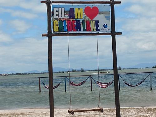 a sign that says love my girlfriend on the beach at Apartamento no Golden Lake - pé na areia, agua de côco e cervejinha in Arraial do Cabo