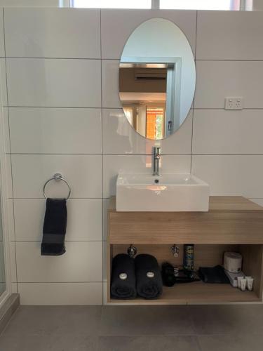 a bathroom with a sink and a mirror at Tarra Motel in Yarram