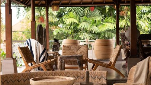 a group of chairs and tables in a patio at Chakra Living Ubud in Ubud