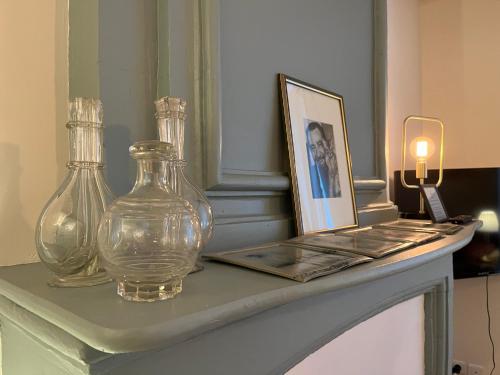 une table avec deux vases en verre et une photo sur celle-ci dans l'établissement Hôtel de Ville 1, à La Rochelle