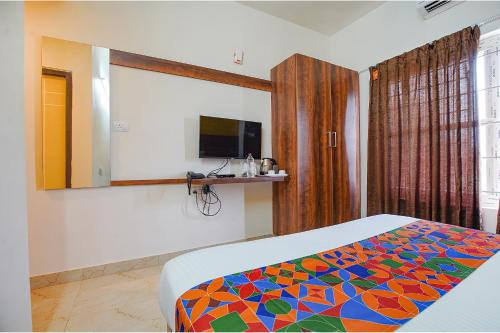 a bedroom with a bed with a colorful blanket at FabHotel Greenwood Xpress Inn - Nr Manipal Hospital in Bengaluru