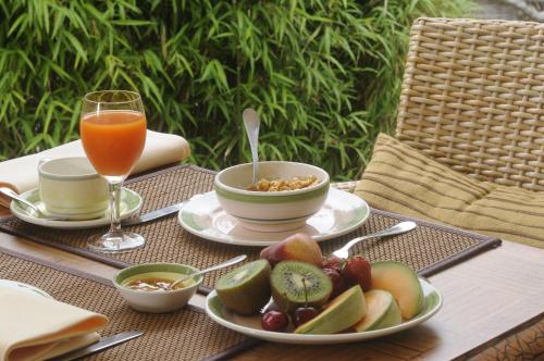 a table with plates of food and a glass of juice at Hotel Martinique in Nieuwpoort