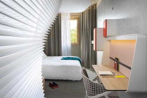 Habitación de hotel con cama, escritorio y habitación en Okko Hotels Grenoble Jardin Hoche, en Grenoble