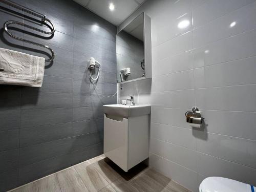 uma casa de banho com um WC, um lavatório e um espelho. em UCU INN - Кімнати для гостей em Lviv