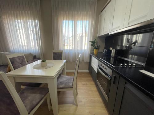 a kitchen with a table and a white table and a kitchen with a stove at Tirana New Bazaar- Apartment no-1 in Tirana