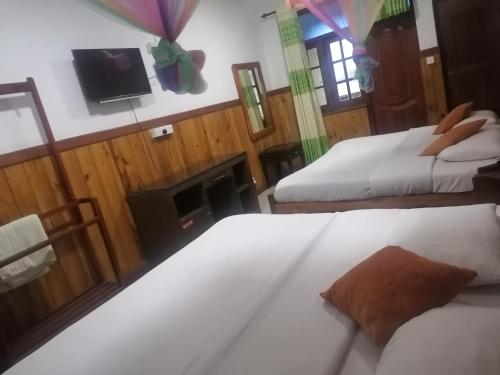a hotel room with two beds and a fireplace at Srilak View Holiday Inn in Haputale