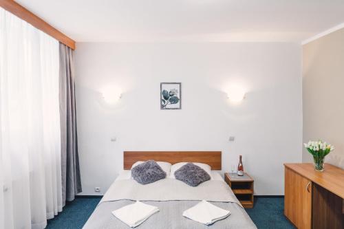 1 dormitorio con 1 cama con sábanas y almohadas blancas en Ondraszek en Ustroń