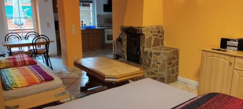 a living room with a stone fireplace and a table at Gästewohnung am Thümmlitzwald in Grimma