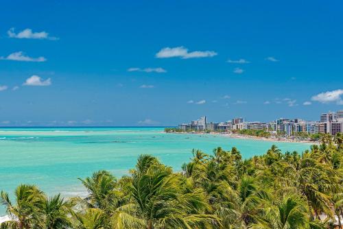 a view of a beach with palm trees and buildings at Jatiúca Suites Resort by Slaviero Hotéis in Maceió