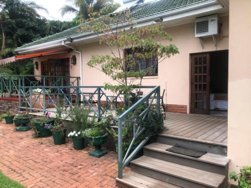 a porch of a house with potted plants at A boutique lodge situated in a serene environment - 2023 in Harare