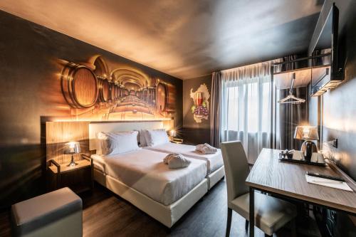 een hotelkamer met een bed en een bureau bij Muraless Art Hotel in Castel d'Azzano