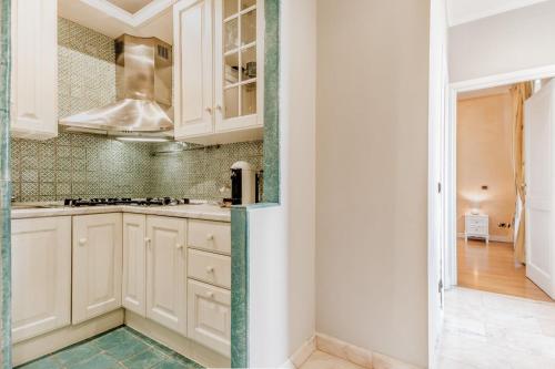 a kitchen with white cabinets and green tiles at APT ROME - Pietra in Rome