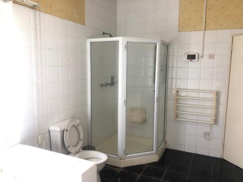 a bathroom with a shower and a toilet at A boutique lodge situated in a serene environment - 2029 in Harare