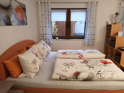 a bed with two blankets and pillows on it at Ferienwohnung Kiruga in Kippenheim