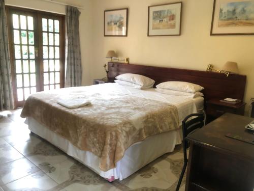 um quarto com uma cama grande e lençóis brancos em A boutique lodge situated in a serene environment - 2021 em Harare