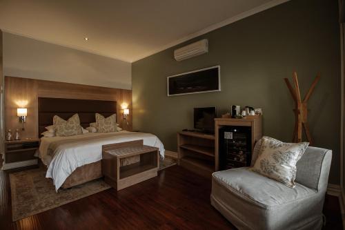 1 dormitorio con 1 cama y 1 silla en The 5 Stars Sandalwood Lodge in Mount Pleasant - 2020, en Kingsmead