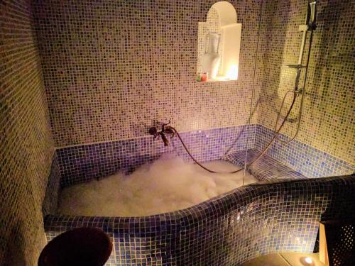 y baño con bañera llena de espuma. en Casas Cuevas El Mirador con piscina y barbacoa, en Fontanar