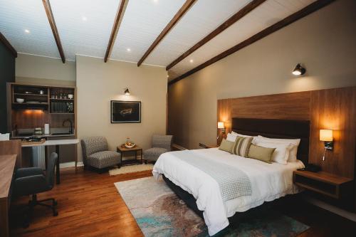 sypialnia z łóżkiem, biurkiem i krzesłami w obiekcie 5 Stars Sandalwood Lodge is situated in Mount Pleasant - 2019 w mieście Kingsmead