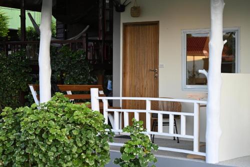 a porch with a white fence and some plants at Bao Village in Haad Yao